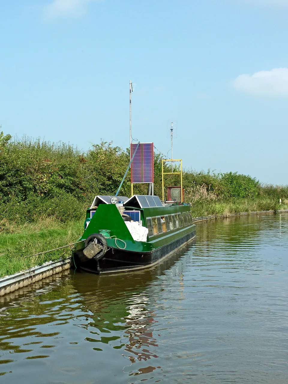 Barco de canal con paneles solares sobre una estructura en el techo