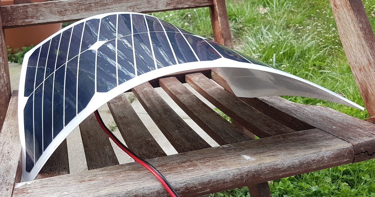 Panel solar flexible curvado sobre un soporte de madera, adaptándose a la superficie